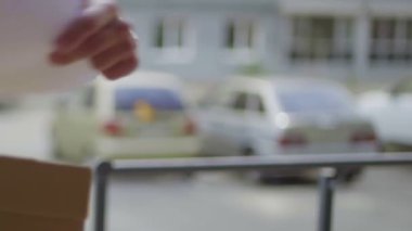 Kurye bir paket teslim eder, genç bir kadın bir kutu alır. Teslimat servisi.