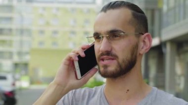 Erkek kurye bir müşteriyi telefonla arar ve teslimat adresini belirtir.