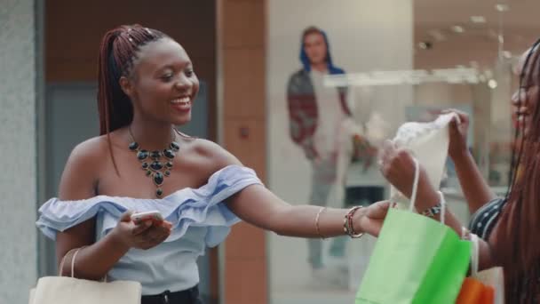 Detailní záběr mladé africké dívky ukazuje svému příteli, jaké věci si koupila — Stock video