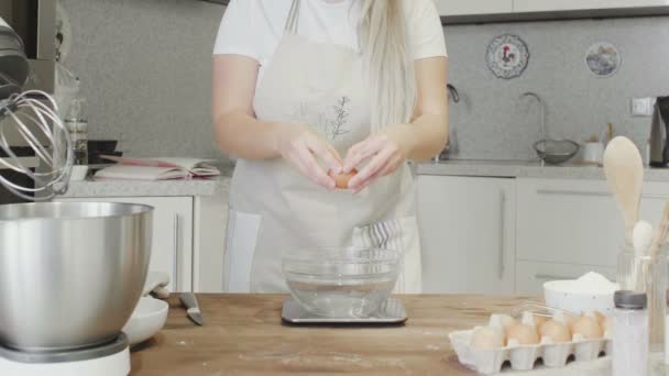 厨房里漂亮的姑娘把鸡蛋打成玻璃碗 — 图库视频影像