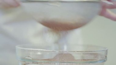 Mutfakta bir kız cam bir kaseye un döküyor.