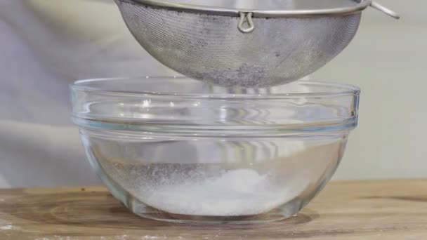 Une fille dans la cuisine verse de la farine dans un bol en verre gros plan — Video