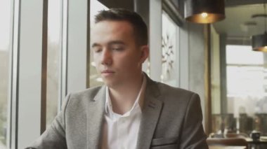 Bir erkek ve bir kadın menüden bir yemek seçiyorlar, pencerenin yanındaki bir kafede karşılıklı oturuyorlar. Hoş bir çiftin randevusu var..