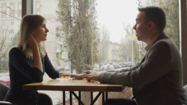 Bir erkek ve bir kadın bir kafede ya da restoranda karşılıklı oturup iletişim kurarlar. Kafede ya da restoranda bir randevu. Romantik atmosfer