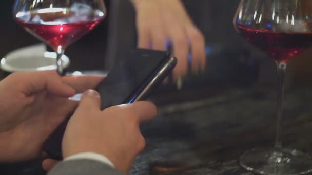 Un homme à un rendez-vous avec une femme paie une facture dans un café ou un restaurant en utilisant NFC close-up — Video