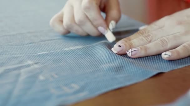 Close-up de mulheres mãos desenhando um padrão no tecido com giz. Uma costureira feminina está a trabalhar — Vídeo de Stock