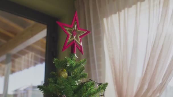En dekorerad julgran bredvid fönstret i huset. Nytt år. — Stockvideo