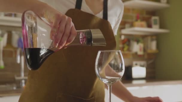 Μια αγνώριστη γυναίκα ρίχνει κρασί από μια καράφα σε ένα όμορφο ποτήρι. Κοντινό πλάνο. — Αρχείο Βίντεο