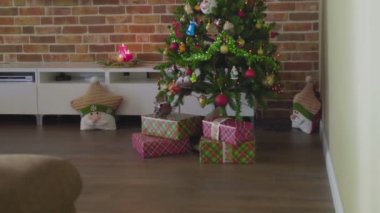 Sarışın güzel bir kız Noel ağacının altına hediye koyar. Yeni yıl arifesi. Sıcak atmosfer