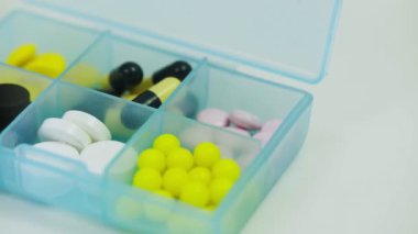 Her hücrede farklı tabletler bulunan bir ilaç kutusuna yakın plan.