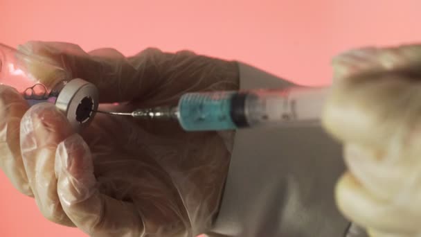 Doktorun elleri kırmızı arka planda aşı için aşı hazırlıyor. — Stok video