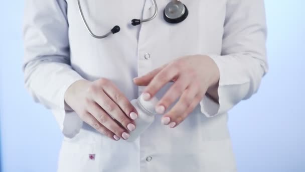 Крупним планом невпізнавана жінка, лікар, тримає банку таблеток і кидає її в руку — стокове відео