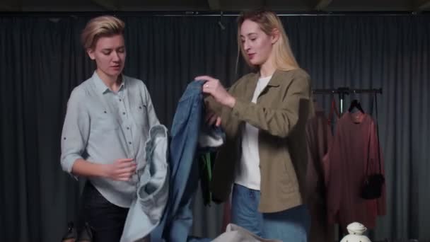 Two happy women are folding clothes, putting things in order — Stock Video