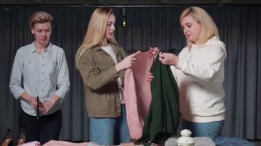 Üç mutlu kadın elbiselerini askıya asar, işleri yoluna koyar.