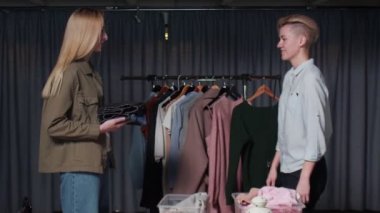 Bir kadın küçük bir yığın eşyayı başka bir kadının ellerine bırakır. Yakın plan.