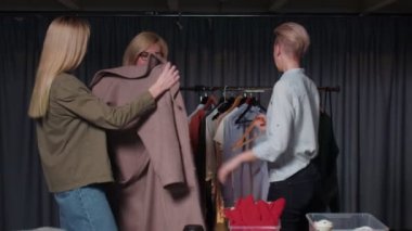 Bir giyim mağazasındaki kadınlar kendileri için bir şeyler seçer, giysi denerler. Giyim mağazalarına bir gezi.