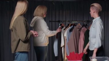 Bir giyim mağazasındaki kadınlar kendileri için bir şeyler seçer, giysi denerler. Giyim mağazalarına bir gezi.