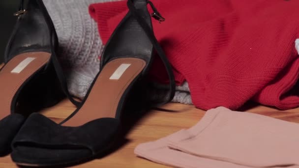 Na stole są buty, dżinsy, sweter, kurtka, koszulka, książki. Film w ruchu — Wideo stockowe