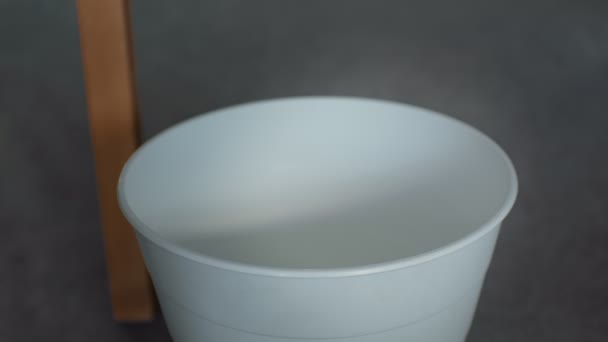 Qualcuno getta una tazza di caffè vuota nella spazzatura in ufficio o a casa, primo piano. — Video Stock