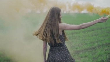 Mutlu genç kadın çiçek Yazdır açık geen alanında eğleniyor ile koyu elbiseli. Ağır çekim güzellik kız portakal duman bombası iplik ve laughing.wonderful smile.middle ile vuruldu