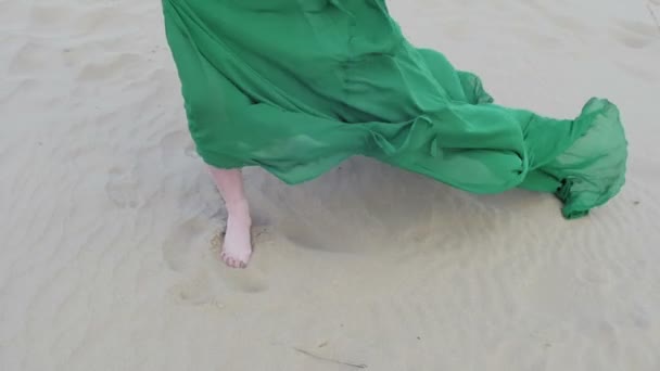 Schoonheid meisje in groene jurk uitgevoerd op zand-duin terwijl wind waait haar kleren slowmotion vooraanzicht voet close-up — Stockvideo