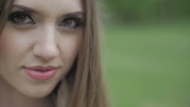 Vacker kvinna med gröna ögon och brunt hår ser på kameran ultrarapid platt färg — Stockvideo
