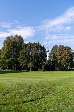Television Tower Landmark, Fernsehturm in Mannheim, Baden-Wuerttemberg, Germany on a cloudy day from afar with some green plains before it