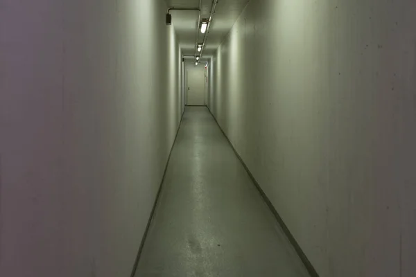 Long, tight and empty hallway on an eye-level angle with yellow-greenish light
