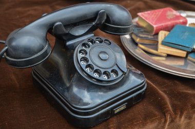Old vintage rotary dial black telephone on brown velvet clipart