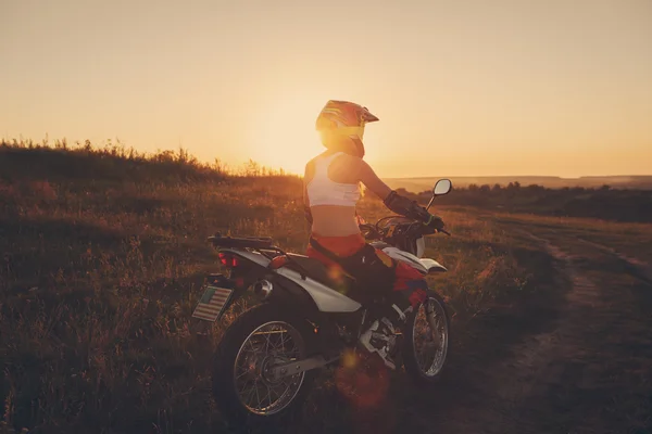 A naplemente, női motorkerékpár nő motoros. — Stock Fotó