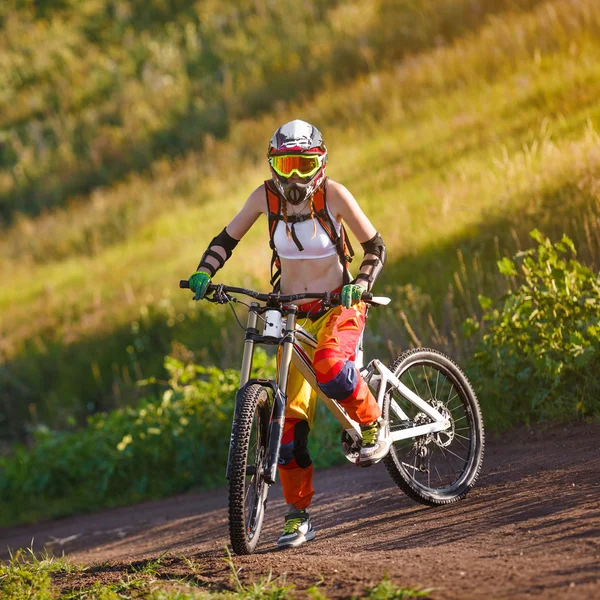 Extreme sports - young woman riding downhill bike — Stock Photo, Image