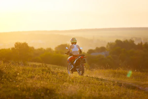 Mujer motociclista en la puesta del sol, motocicleta femenina . — Foto de Stock