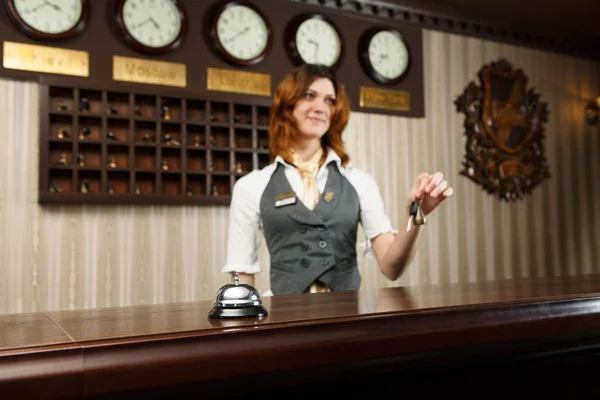 Hotel receptionist and counter desk with bell — Stock Photo, Image