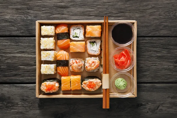 Set sushi maki en rollen in zwart rustiek hout. — Stockfoto