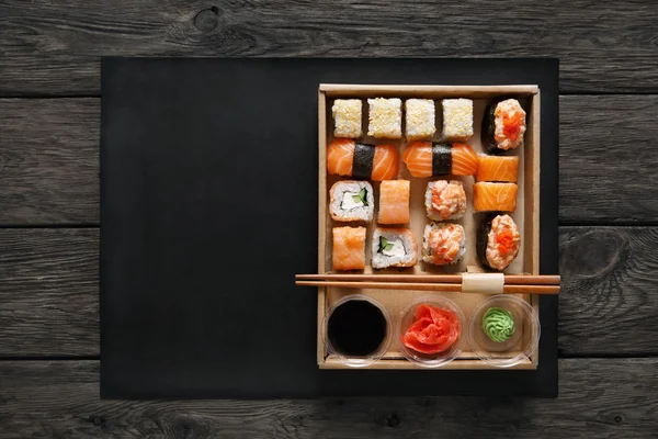 Zestaw sushi maki i rolki w czarny drewno rustykalne. — Zdjęcie stockowe