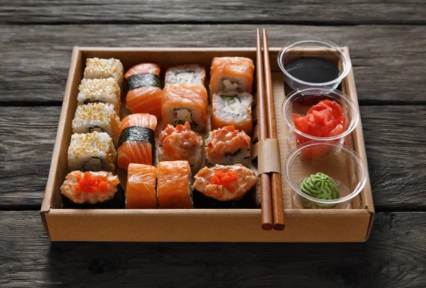 Set sushi maki en rollen in zwart rustiek hout. — Stockfoto