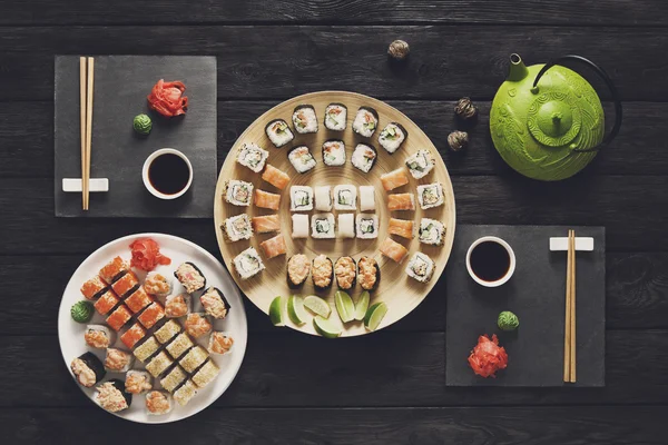 Set Sushi Maki und Rollen aus rustikalem schwarzem Holz. — Stockfoto