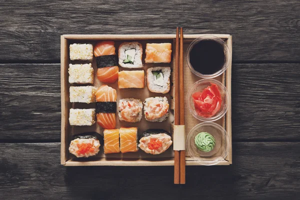 Uppsättning av sushi maki och rullar på svart rustikt trä. — Stockfoto