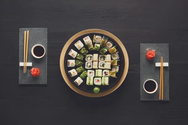 Set of sushi maki and rolls at black rustic wood. — Stock Photo, Image