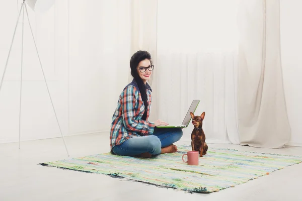 Giovane ragazza sul divano bianco con un computer portatile . — Foto Stock