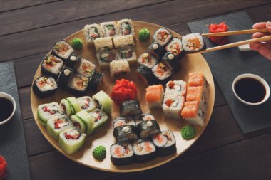 Suşi maki ve rulo siyah rustik ahşap.