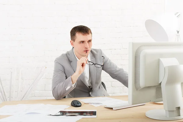 Jeune homme d'affaires au bureau avec ordinateur — Photo