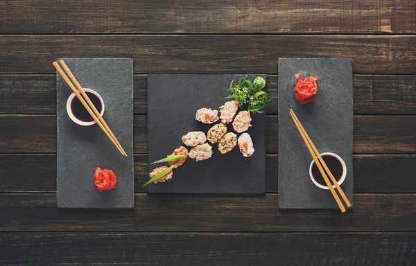 Zestaw sushi maki i rolki w czarny drewno rustykalne. — Zdjęcie stockowe