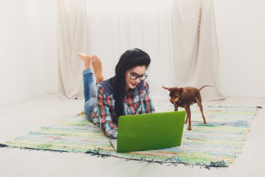 Bir dizüstü bilgisayar ile beyaz kanepe üzerinde genç kız.