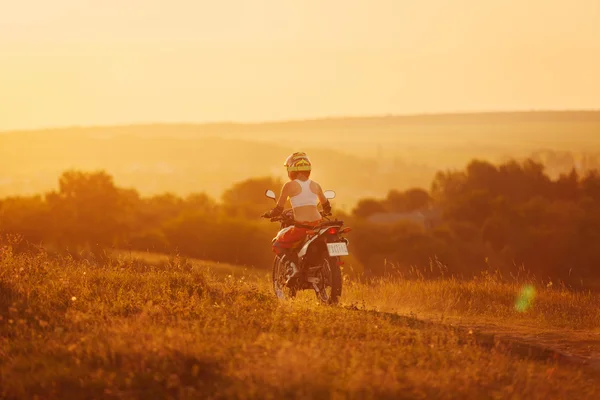 Mujer motociclista en la puesta del sol, motocicleta femenina . — Foto de Stock