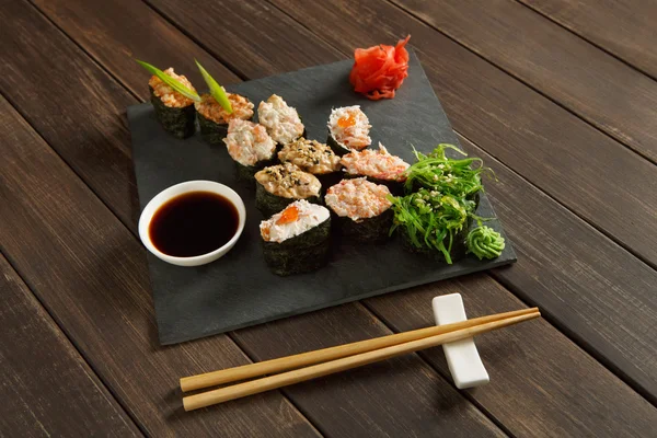 一整套寿司寿司和质朴的黑色木材的辊轴. — 图库照片