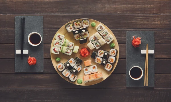 Set of sushi maki and rolls at black rustic wood. — Stock Photo, Image