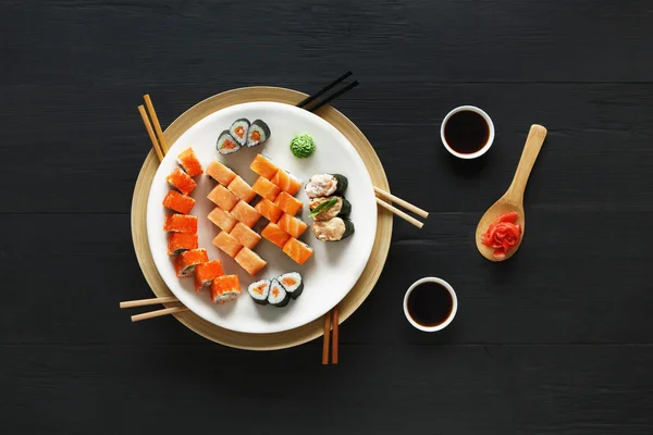 Set Sushi Maki und Rollen aus rustikalem schwarzem Holz. — Stockfoto