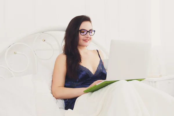 Giovane donna legge da tablet pc a letto, tasto alto — Foto Stock