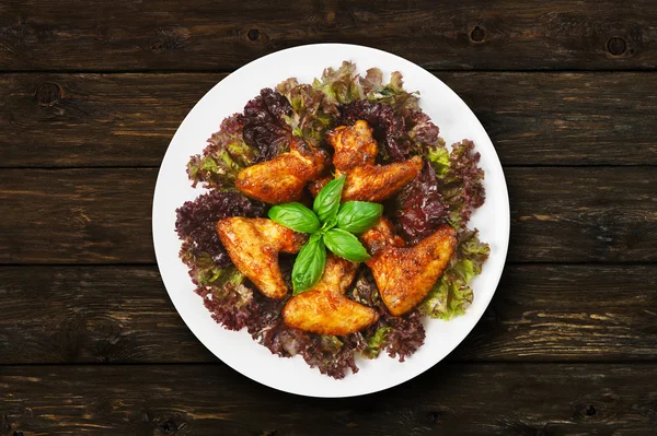 Fried roasted chicken wings on lettuce — Stock Photo, Image